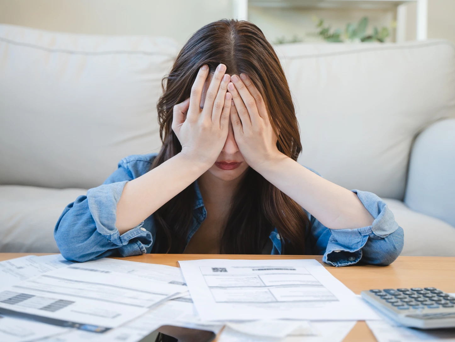 Person reviewing debt and credit card bills with a concerned expression
