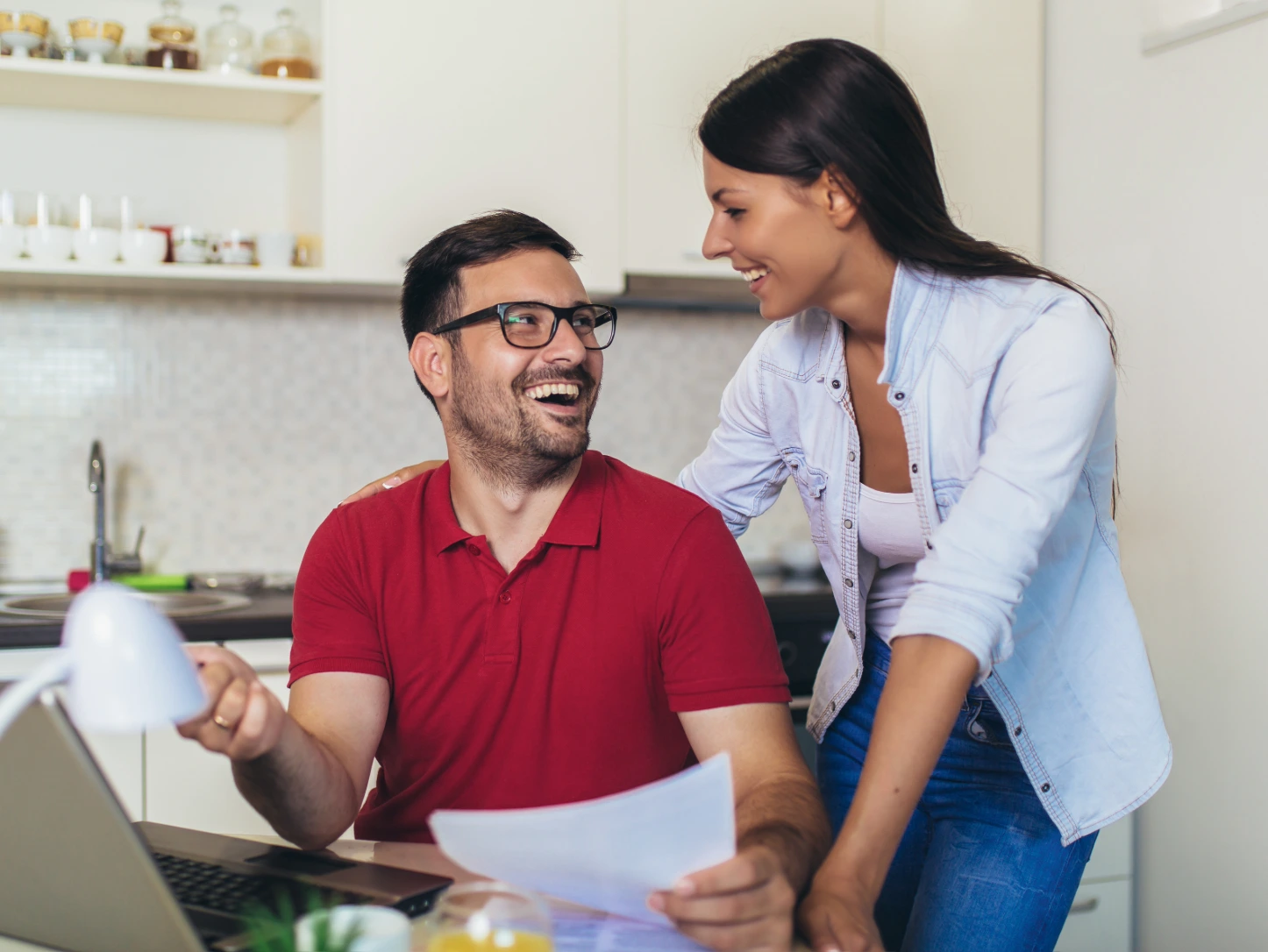 Couple reviewing mortgage pre-approval documents at a kitchen table